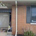 Desert Tan downspout tied into an underground drain beside a brick home in Berrien Springs, MI