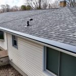 Close-up of Charcoal Gutter Topper over Almond gutters below new Georgetown Gray shingles in Baroda, MI