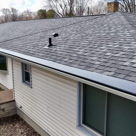 Close-up of Charcoal Gutter Topper over Almond gutters below new Georgetown Gray shingles in Baroda, MI