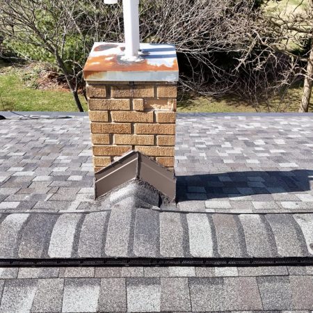 Chimney with a new flashing kit next to CertainTeed ridge vent and Georgetown Gray ridge caps