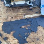 Old roof decking with leftover ice and water shield stuck to it after tear-off in Baroda, MI