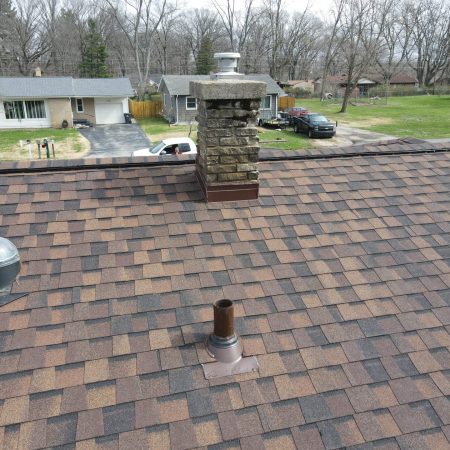 Chimney with new saddle and flashing and a re-flashed round skylight on a Coloma, MI roof