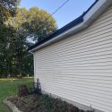 Hobart, IN home with new seamless black gutters, white downspouts, and white aluminum fascia