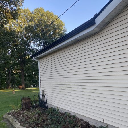 Hobart, IN home with new seamless black gutters, white downspouts, and white aluminum fascia
