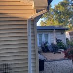 Hobart IN Gutters 05 White aluminum-wrapped fascia with black gutter and white downspout in Hobart, IN