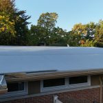 St Joseph MI Heated Gutter Topper 01 Low-pitch rubber roof edge with Tan Gutter Topper on a St. Joseph, MI home