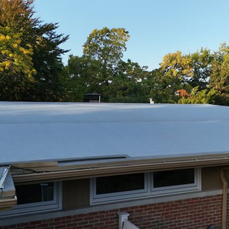 Low-pitch rubber roof edge with Tan Gutter Topper on a St. Joseph, MI home