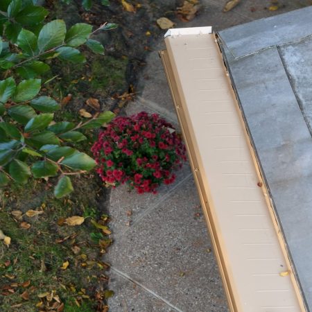 Fascia-mounted Tan Gutter Topper above the yard of a St. Joseph, MI home